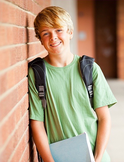 boy smiling with backpack on