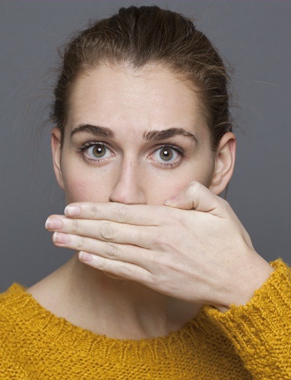 woman hiding her mouth with her hand before restorative dentistry in Fort Smith