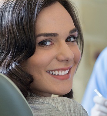 woman in dental chair smiling over shoulder