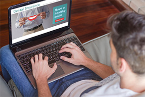 Man looking at dental insurance website on laptop