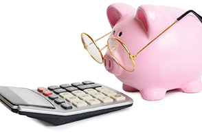 Piggy bank wearing glasses and looking at calculator