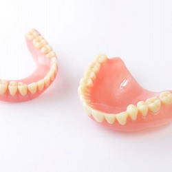 Closeup of full dentures on white background