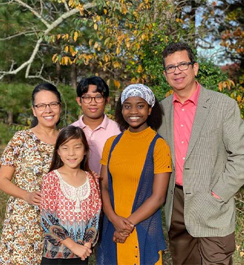 Doctor Lopez smiling with his family outdoors