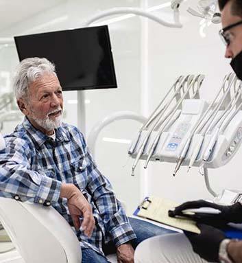 Older man speaking with a dentist
