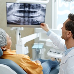 Dentist going over mouth X-Ray with patient