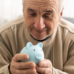 Man holding a small blue piggy bank