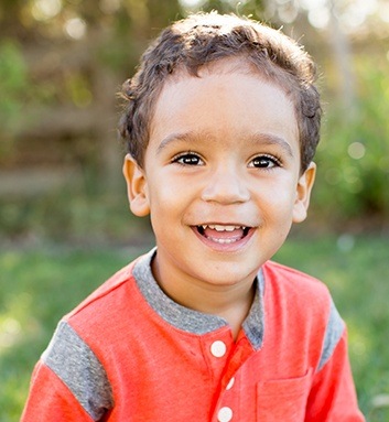 little boy smiling outside