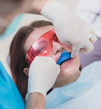 girl in dental chair with fluoride trays on her teeth