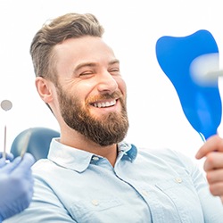 man smiling while looking in mirror