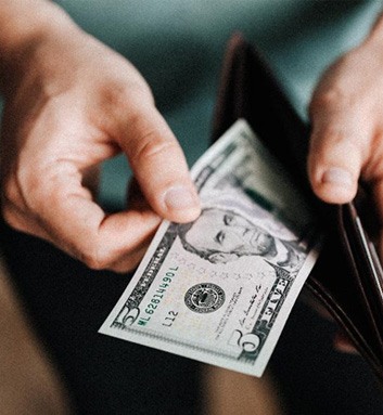 Man looking at cash in wallet