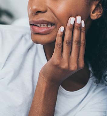 Woman in pain holding cheek