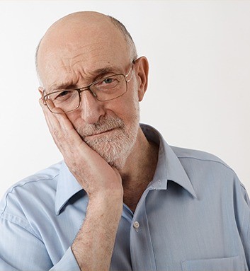 man holding his cheek in pain