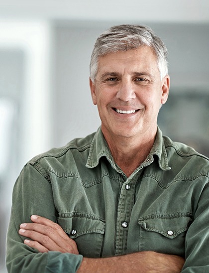 man in green shirt smiling with dental implants in Fort Smith