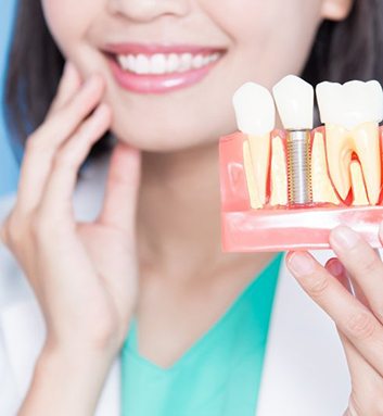 dentist showing a model of how dental implants work