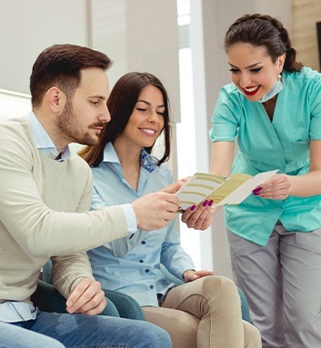 Dental assistant showing couple paperwork