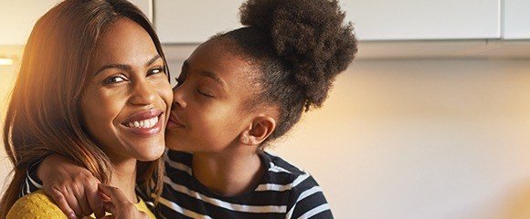 Young girl kissing her mother on the cheek