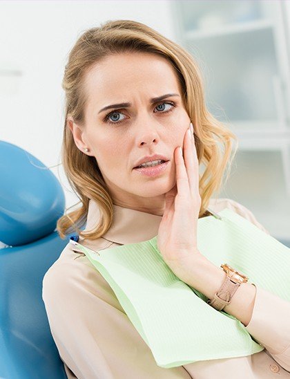 woman holding her cheek in pain before root canal treatment in Fort Smith