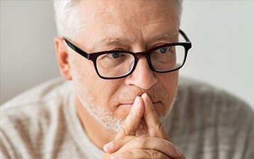 man with glasses thinking