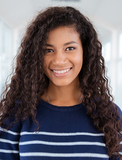 teen in striped sweater smiling after wisdom tooth extractions in Fort Smith