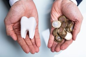 person holding money in one hand and a tooth in the other