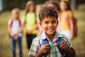 Young child smiling on his way back to school.