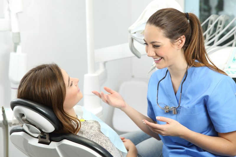 dental hygienist helping patient