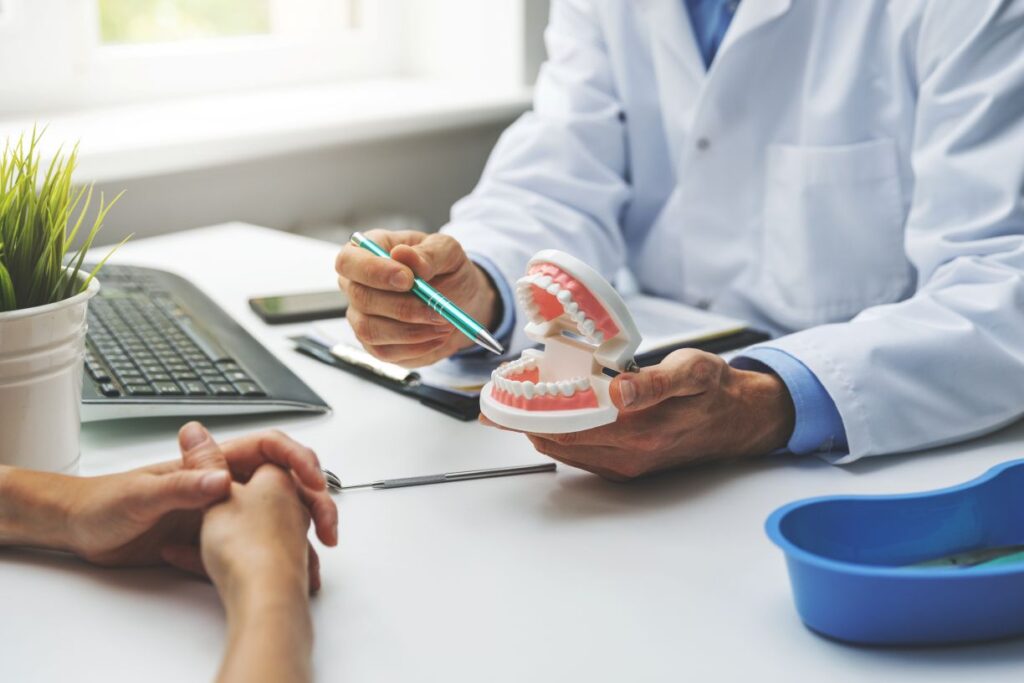 A dentist showing a patient a model of a dental implant